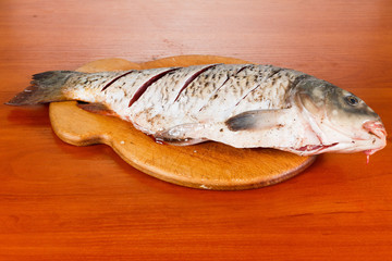 Cutting fresh fish carp before baking