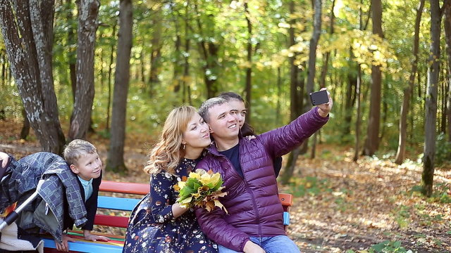 Autumn scene of Happy young family taking selfies with her