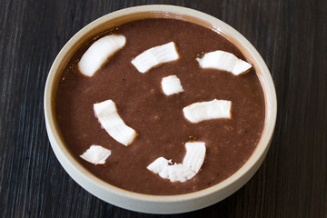 Bowl of frozen acai with banana and coconut garnish over brown wooden background