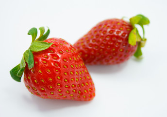 Two strawberries close up on white background