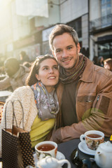 Backlit shoot. Trendy couple having fun and sitting at a terrace