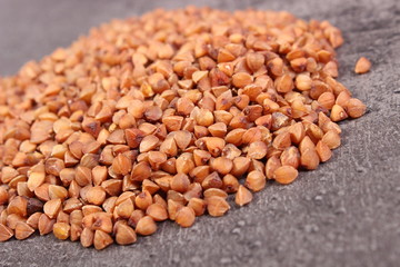 Heap of buckwheat groats on cement structure