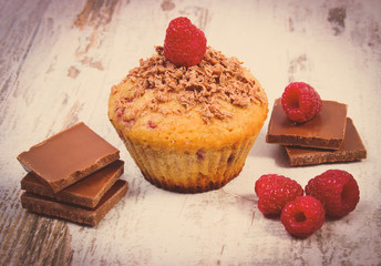 Vintage photo, Fresh baked muffins with raspberries and chocolate on wooden background, delicious dessert