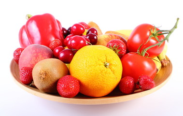 Fresh fruits and vegetables on wooden plate