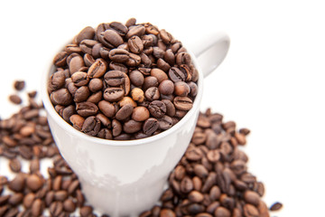 Cup full of coffee beans. All on white background