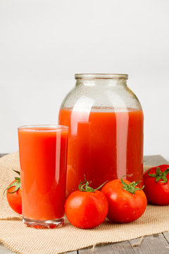 Tomato juice in glass and two-liter jar