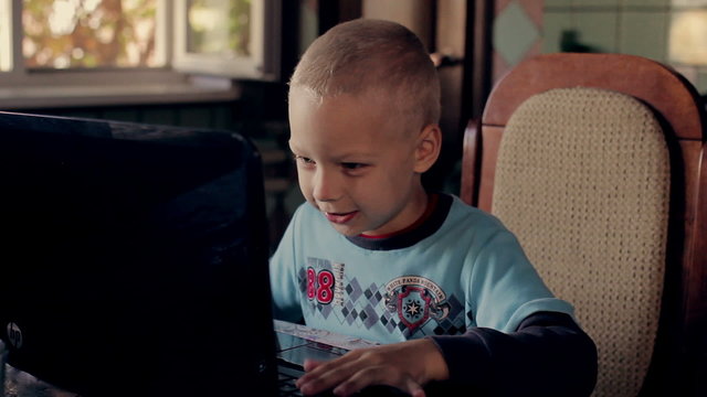 5 years old boy playing on  the computer at  home