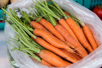 close up of carrot in plastic bag at street market