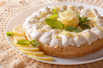 lemon tart with meringue and mint close-up on a plate. horizontal
