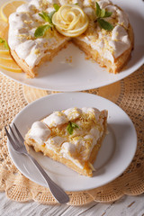 Delicious sliced lemon meringue cake close up on the table. vertical
