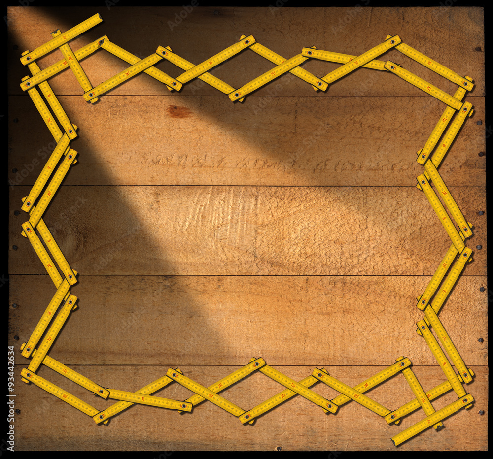 Poster wooden background with ruler frame / border frame made from a old wooden ruler on a weathered wooden