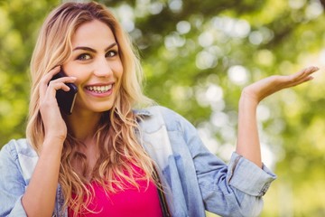 Portrait of smiling woman gesturing while using smartphone 