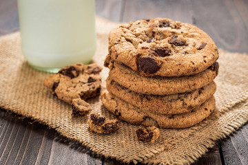Chocolate chip cookies with milk on wooden table