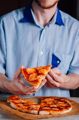 Young man eating pizza Margherita