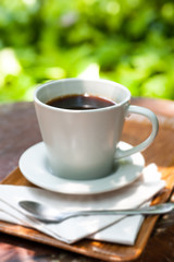 cup of espresso coffee with green garden background