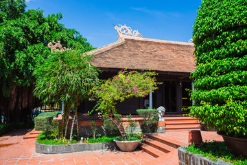 Fototapeta na wymiar Vietnamese courtyard with trees, a fountain and houses covered w