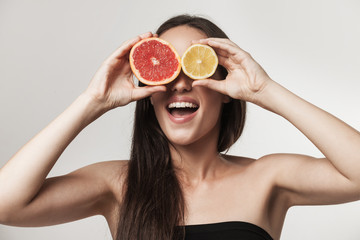 Portrait of young woman holning lemon ang grapefruit