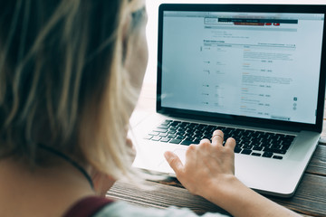 Woman working with laptop placed on wooden desk