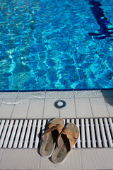 flip flops beside blue pool