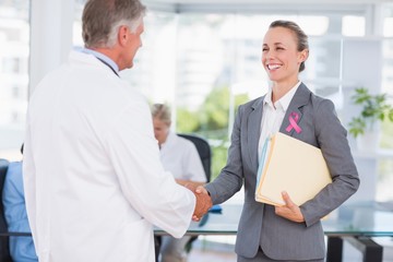Obraz na płótnie Canvas Doctor and businesswoman handshaking