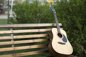 beautiful photo guitar on a bench in nature