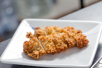 Japanese fried pork name is tonkatsu in white dish