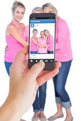 Composite image of female hand holding a smartphone