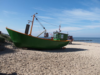 Naklejka na ściany i meble green fishing boat at sea coast