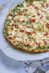 Vegetarische Zucchinitarte mit Feta und Tomaten auf Backpapier, Leinenserviette,