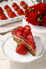Piece of strawberry cake on white ceramic cake stand