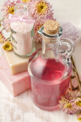 Fototapeta na wymiar Bottle of pink liquid soap and bottle of sea salt