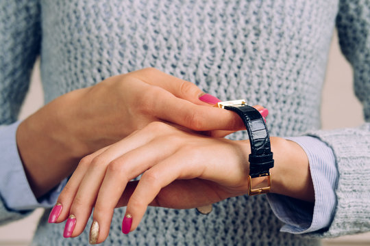Female hands with a bright manicure dress watch on wrist