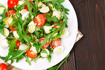 Salad with arugula on a wooden background