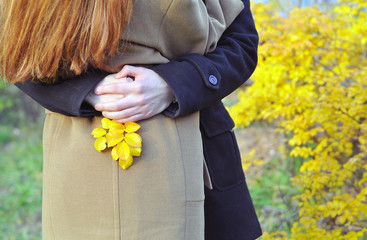 Couple in love hug in autumn forest with yellow leaves