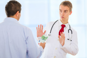 Man offering money to a doctor in order to bribe him but the doctor is strongly refusing it.