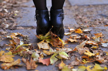 Autumn leaves on the heels of woman in the park