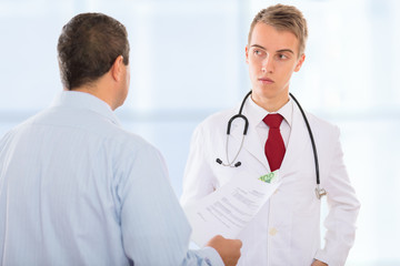 Fototapeta premium Man offering a corrupt doctor bribe money placed in between documents that need to be falsified