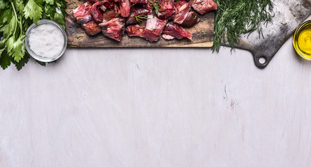 border with Fresh raw sliced lamb meat cleaver oil salt herbs on white wooden rustic background...
