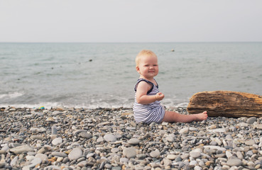 Little girl sitting on the sea beach