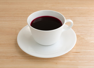 Beet juice in a coffee mug on table top