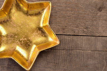 Golden star shaped bowl on wood