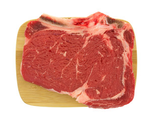 Bone in rib eye steak on wood cutting board