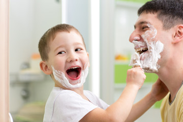 playful father and kid son shaving and having fun in bathroom