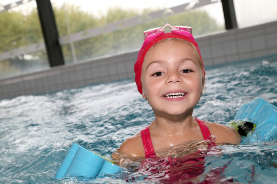 Portrait of 4-year-old girl bathing in swimming pool