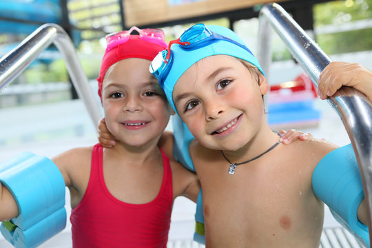 Portrait of cute little kids at the swimming-pool