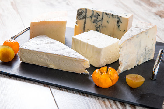Vassoio nero con fette di formaggi e pezzi di mostarda
