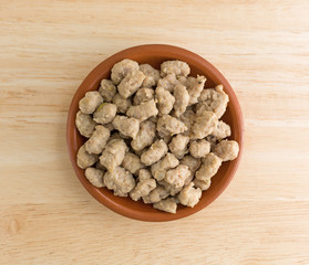 Crumbled Italian sausage in a small bowl on wood