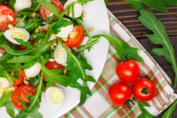 Salad with arugula on a wooden background