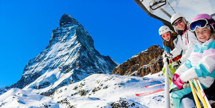 Ski, skiing in Zermatt, Switzerland - skiers on ski lift with view of Matterhorn 
