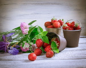 Strawberry in a bucket and flowers